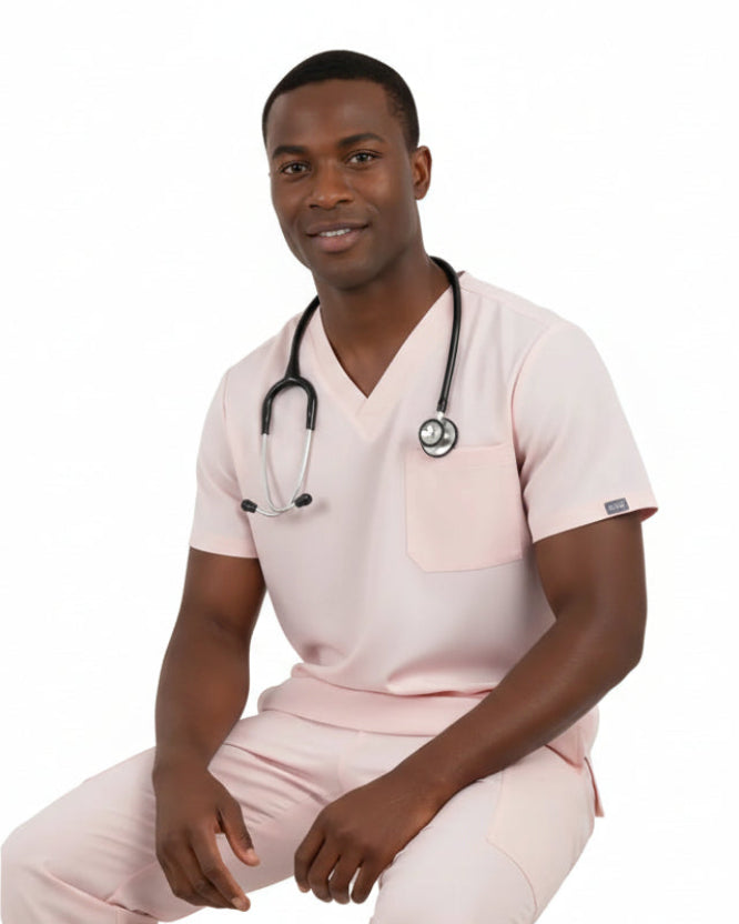 Man wearing a light pink scrub set on a white background