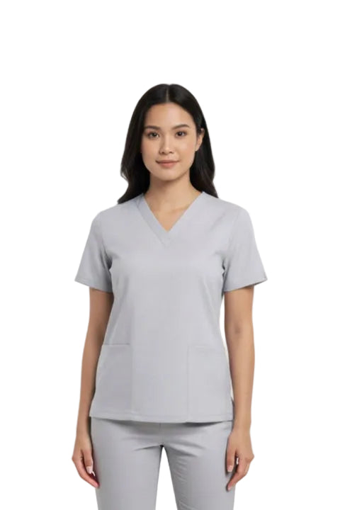 Woman wearing a gray scrub top on a white background