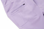 Close-up of a lavender scrub bottom with a pocket and zipper detail.