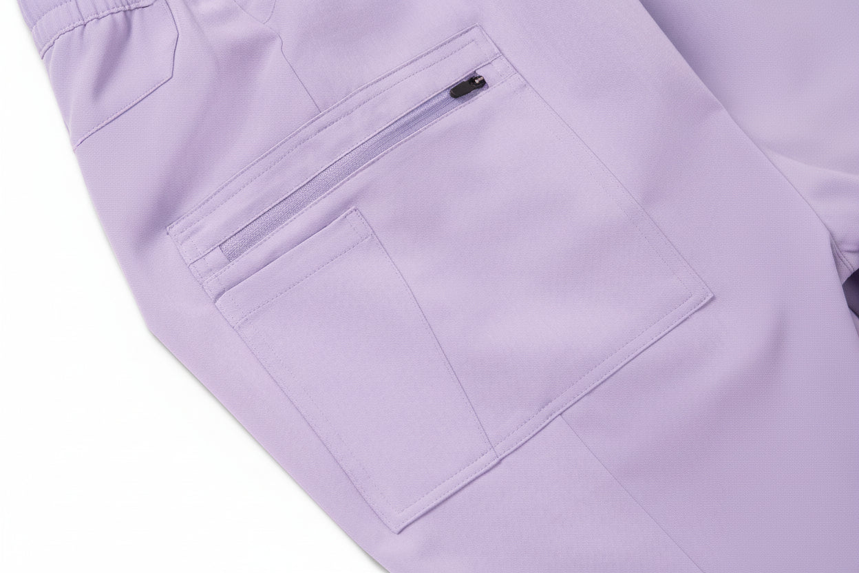 Close-up of a lavender scrub bottom with a pocket and zipper detail.