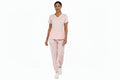 Pink jogger nursing scrub set worn by a healthcare professional walking, featuring a modern athletic fit and stretch fabric