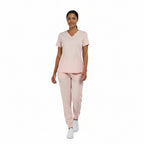 Pink jogger nursing scrub set worn by a healthcare professional walking, featuring a modern athletic fit and stretch fabric